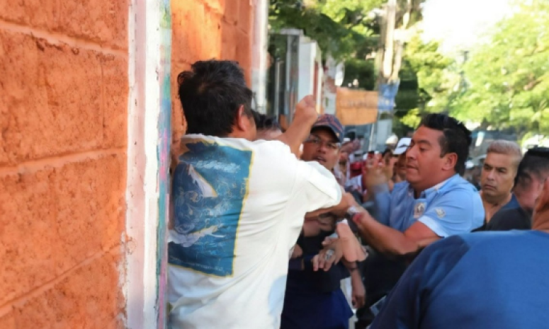 Golpean a mujer al dejar a su hijo a la escuela; papás someten al agresor